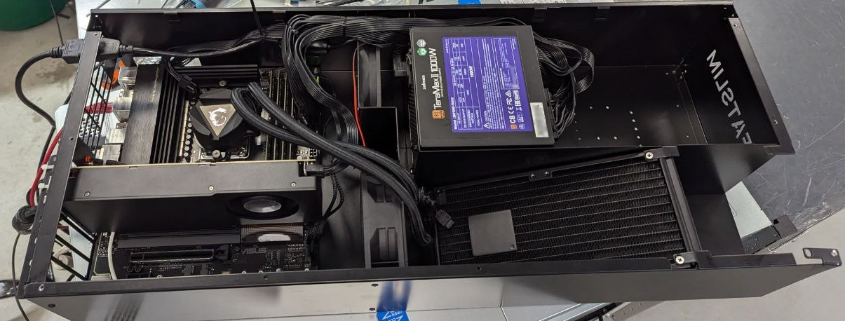 Открытый корпус FatSlim, который шире модели UltraSlim. Внутри установлена большая высокопроизводительная видеокарта рядом с материнской платой и трехсекционной системой жидкостного охлаждения.